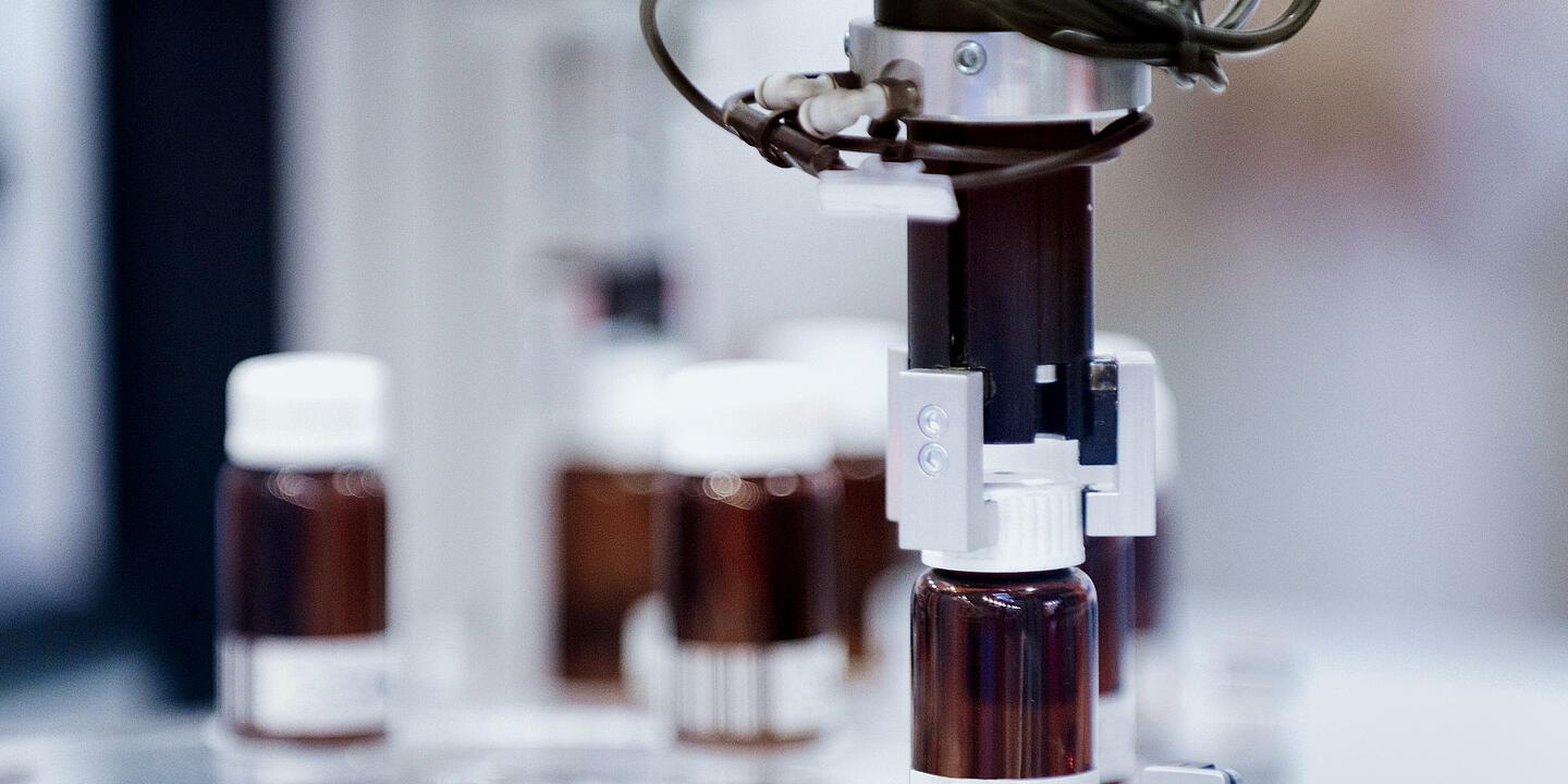 Una macchina di tecnologia di laboratorio avvita i tappi sulle bottigliette