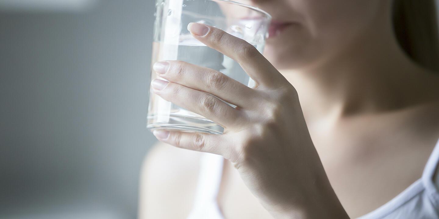 Eine Frau trinkt ein Glas Wasser