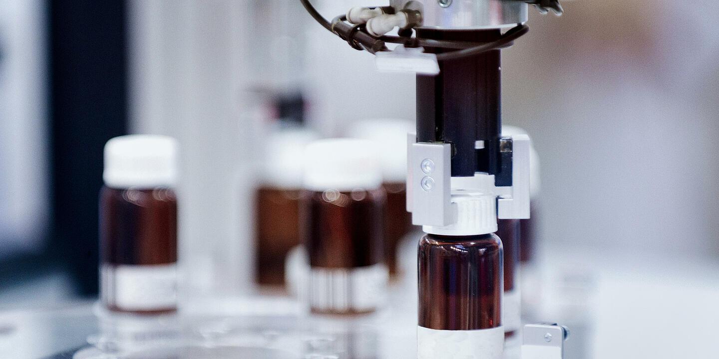 Una macchina di tecnologia di laboratorio avvita i tappi sulle bottigliette